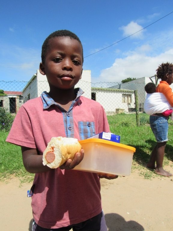 Child receiving a meal container