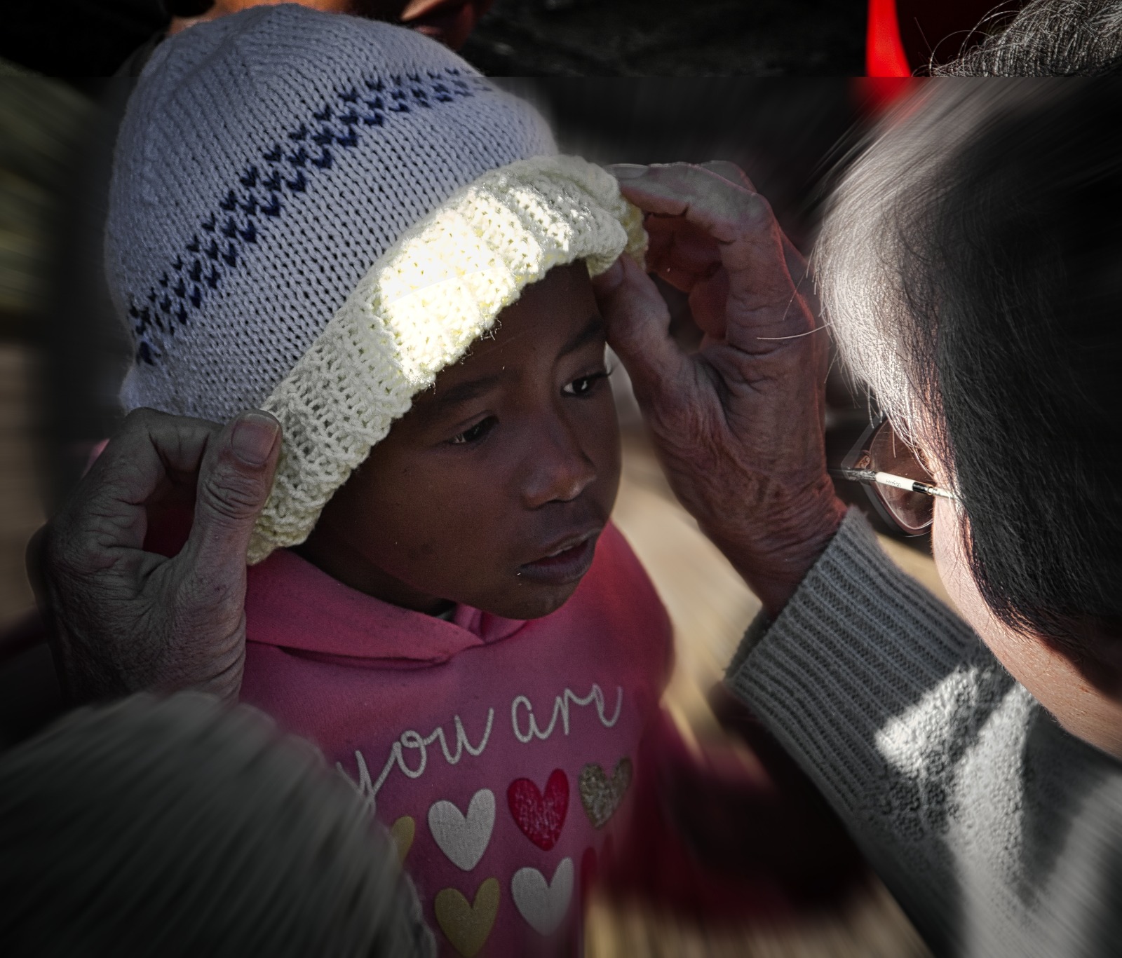 Volunteer adjusting a child's beanie