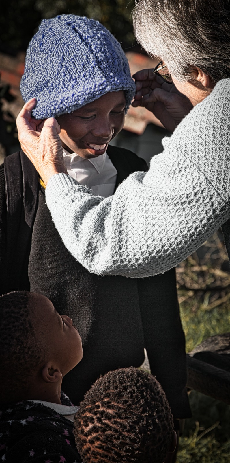 Volunteer fitting a beanie on a child